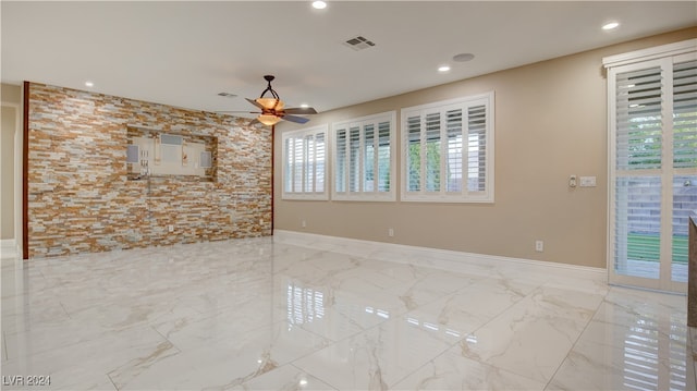 spare room featuring ceiling fan and plenty of natural light