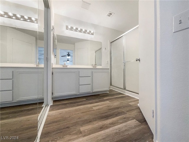 bathroom with wood-type flooring, vanity, and a shower with shower door