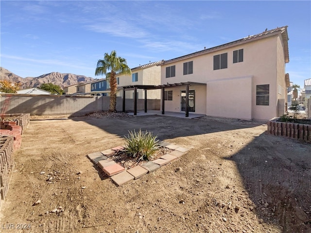 back of property featuring a mountain view and a pergola