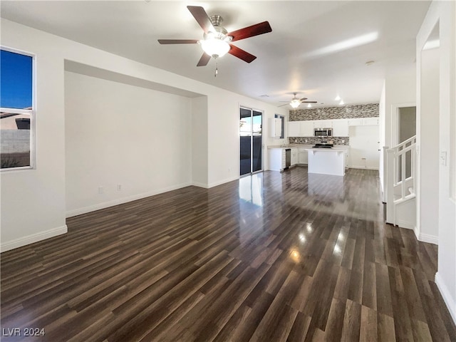 unfurnished living room featuring ceiling fan and dark hardwood / wood-style flooring