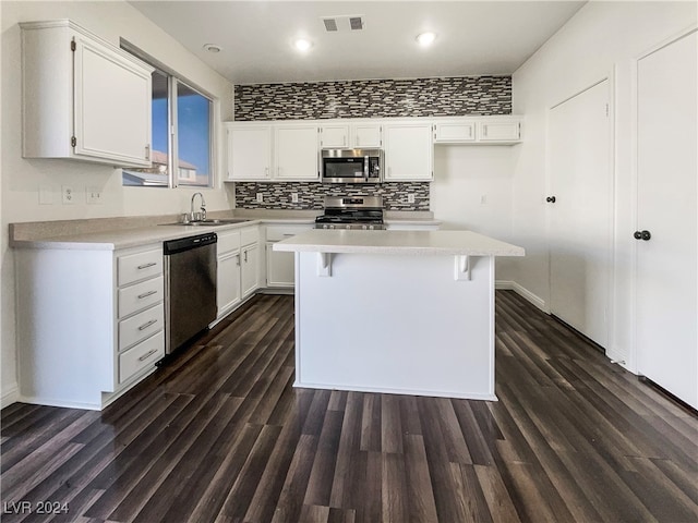 kitchen featuring white cabinetry, sink, dark hardwood / wood-style floors, a kitchen island, and appliances with stainless steel finishes