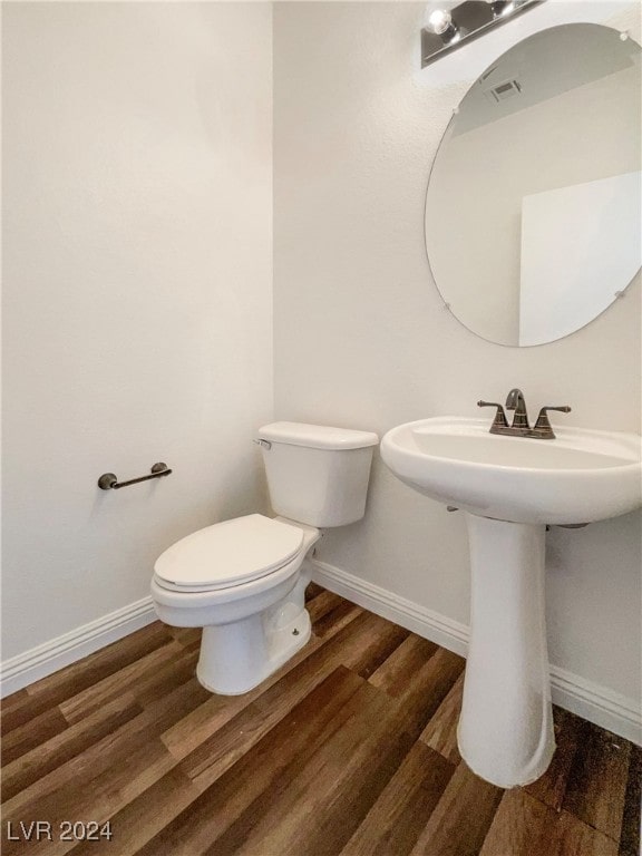 bathroom with wood-type flooring and toilet