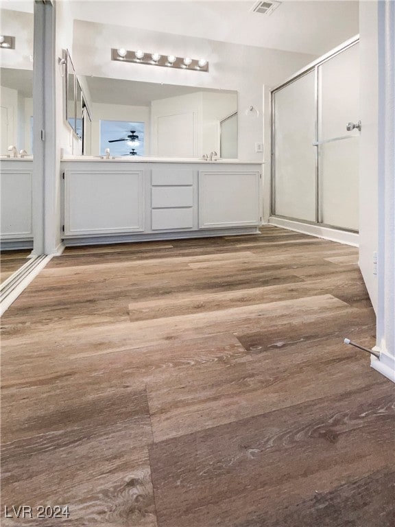 bathroom with vanity, wood-type flooring, and a shower with shower door