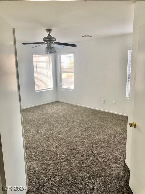 carpeted spare room with ceiling fan