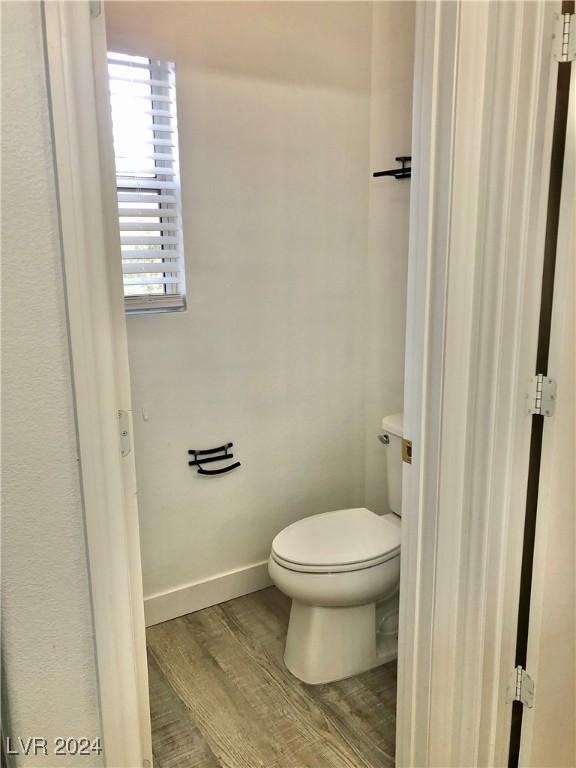 bathroom featuring hardwood / wood-style flooring and toilet