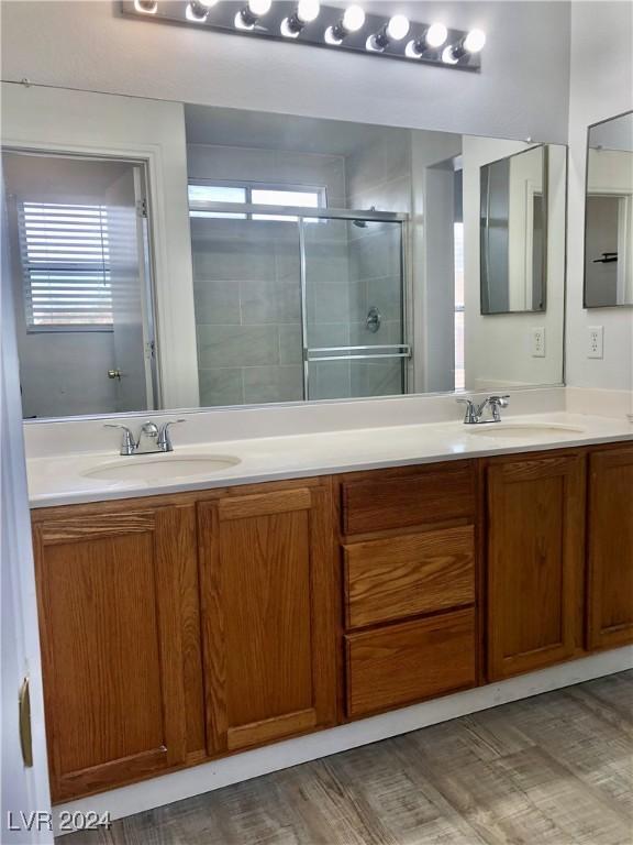 bathroom featuring a shower with door, plenty of natural light, vanity, and wood-type flooring