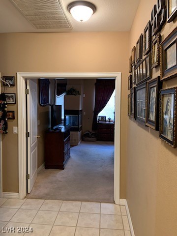 hallway featuring light colored carpet