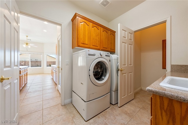 laundry room with washing machine and clothes dryer, ceiling fan, sink, cabinets, and light tile patterned floors