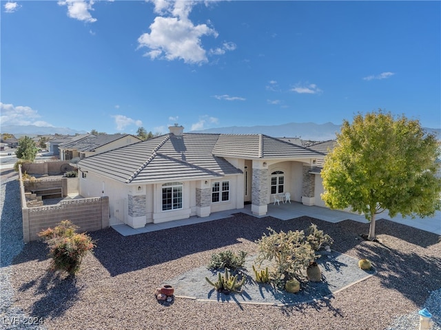 back of house featuring a mountain view and a patio area