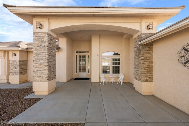 view of exterior entry featuring a patio