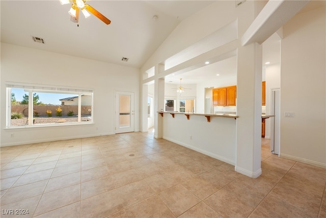 unfurnished living room featuring ceiling fan, lofted ceiling, and light tile patterned flooring