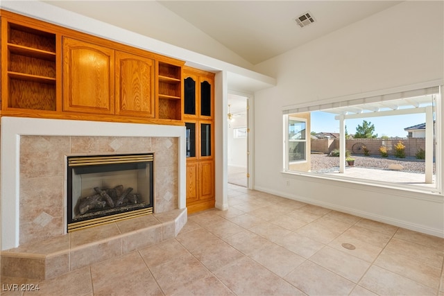 unfurnished living room with light tile patterned floors, a fireplace, and vaulted ceiling