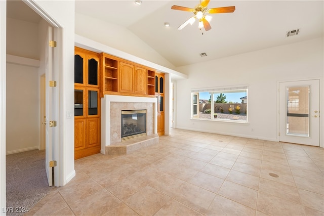 unfurnished living room featuring a fireplace, light tile patterned floors, vaulted ceiling, and ceiling fan