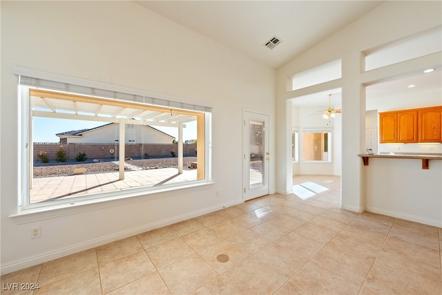 empty room with ceiling fan, light tile patterned flooring, and lofted ceiling