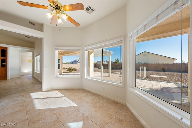 unfurnished sunroom featuring ceiling fan and vaulted ceiling