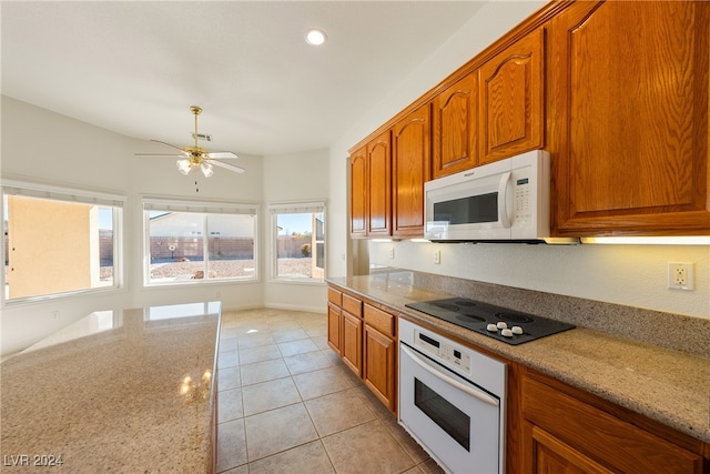 kitchen featuring ceiling fan, light stone counters, white appliances, and light tile patterned floors