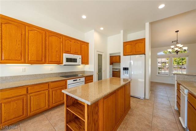 kitchen with a center island, white appliances, an inviting chandelier, decorative light fixtures, and light stone counters