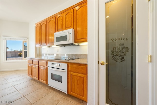 kitchen with light tile patterned flooring and white appliances