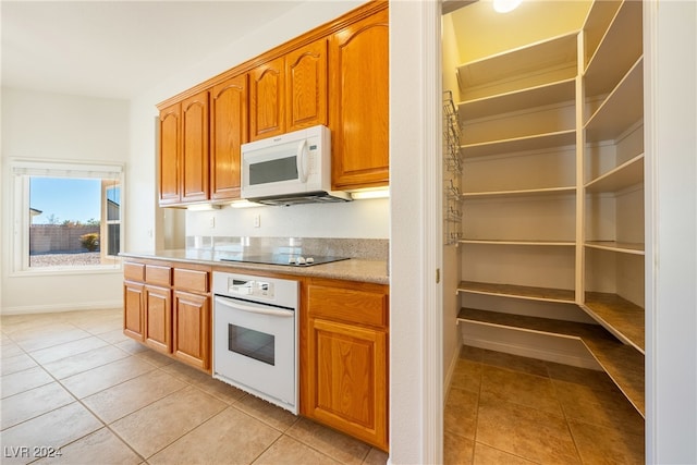 kitchen with light tile patterned flooring and white appliances