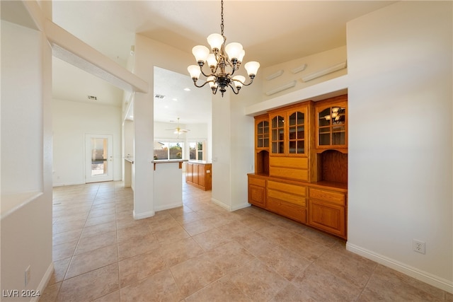 unfurnished dining area featuring light tile patterned flooring and an inviting chandelier