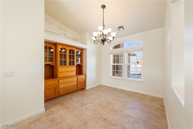 unfurnished dining area with a notable chandelier, light tile patterned flooring, and vaulted ceiling