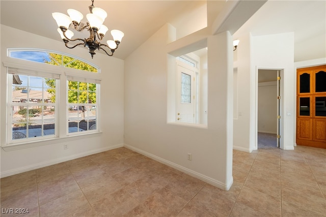 unfurnished room with a chandelier, light tile patterned floors, and vaulted ceiling