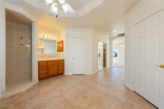 bathroom featuring a tile shower, ceiling fan, tile patterned flooring, and vanity