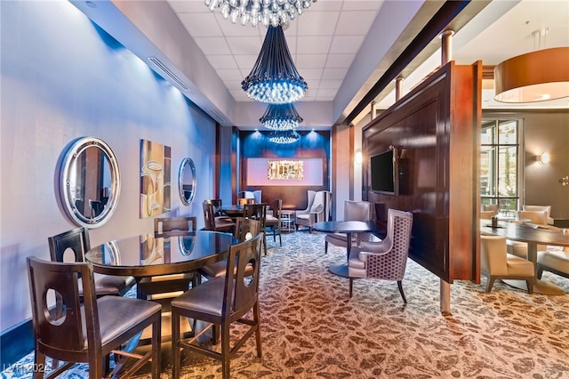 dining area with a paneled ceiling and carpet floors