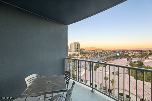 balcony at dusk featuring a city view