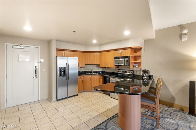 kitchen featuring open shelves, stainless steel appliances, dark countertops, a sink, and a peninsula