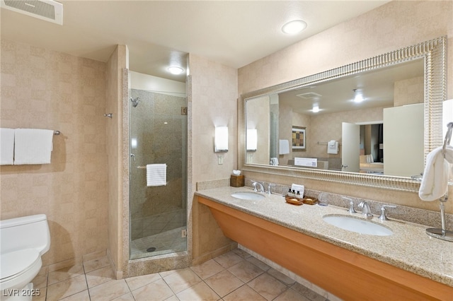 bathroom with visible vents, toilet, tile patterned floors, a shower stall, and a sink