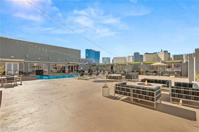 exterior space featuring a view of city, a fire pit, and a community pool