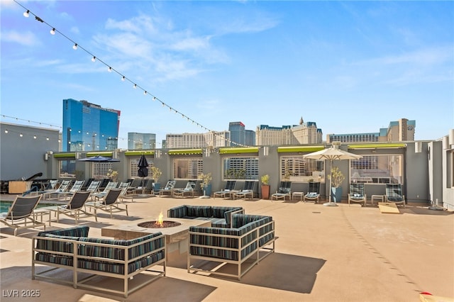 view of patio / terrace with an outdoor fire pit and a city view