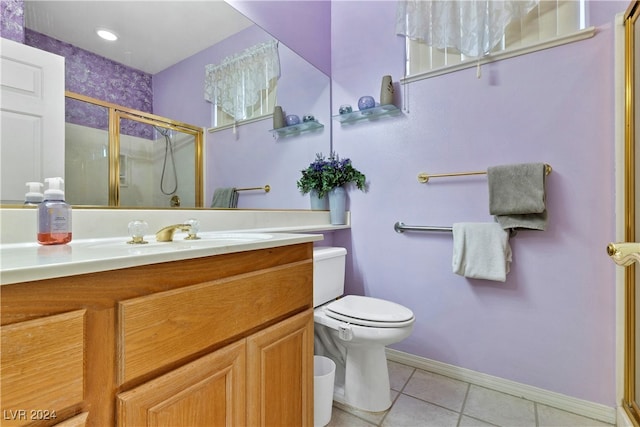 bathroom featuring tile patterned flooring, vanity, toilet, and walk in shower