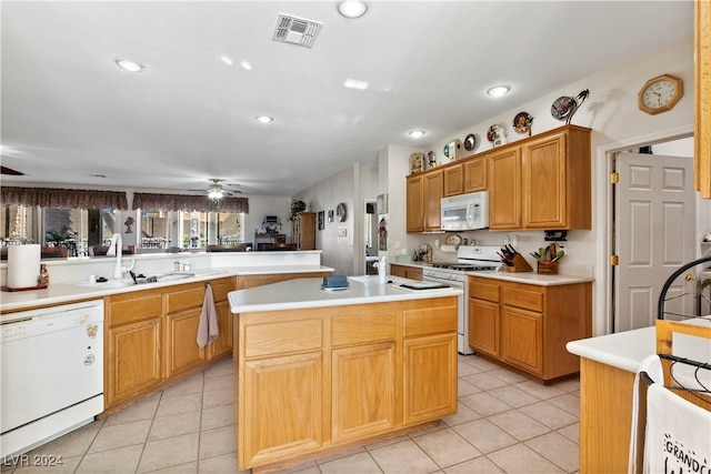 kitchen with ceiling fan, a kitchen island, white appliances, and sink