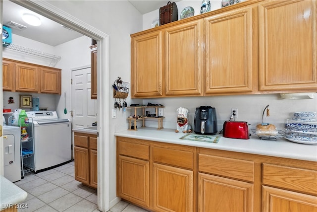 kitchen featuring washer and dryer, light tile patterned floors, and sink