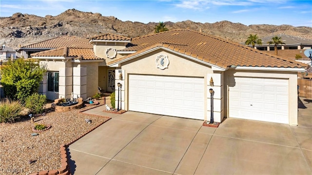 2349 Cottage View Ct, Laughlin, NV 89029 - mediterranean / spanish house featuring a mountain view, driveway, stucco siding, a tiled roof, and a garage