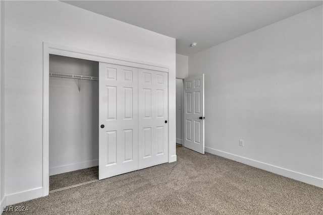 unfurnished bedroom featuring carpet flooring and a closet