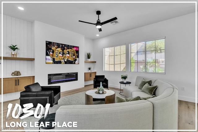 living room with ceiling fan and light wood-type flooring