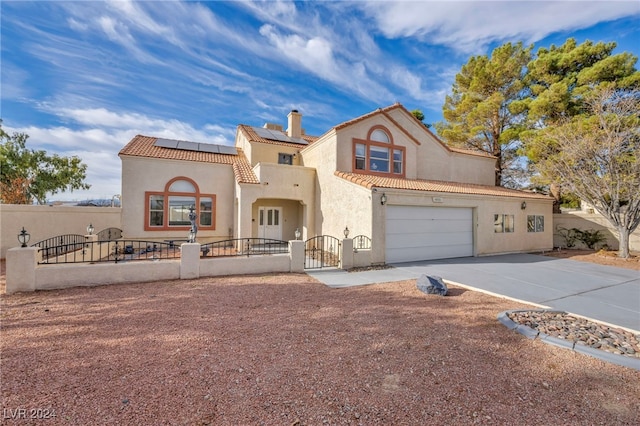 mediterranean / spanish house with a garage and solar panels