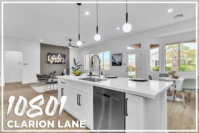 kitchen featuring white cabinetry, sink, hanging light fixtures, light hardwood / wood-style flooring, and stainless steel dishwasher