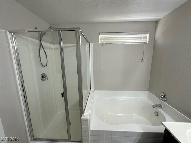 bathroom with vanity, separate shower and tub, and a textured ceiling