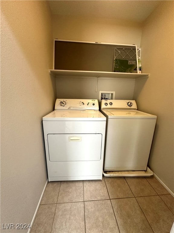 washroom featuring washing machine and clothes dryer and light tile patterned floors