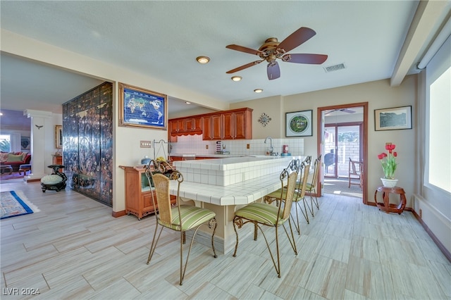 dining area featuring beamed ceiling, a healthy amount of sunlight, and sink