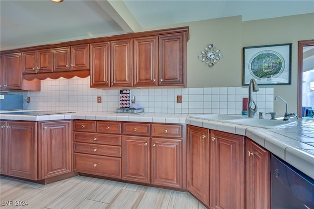 kitchen with sink, stainless steel dishwasher, decorative backsplash, tile counters, and light hardwood / wood-style floors