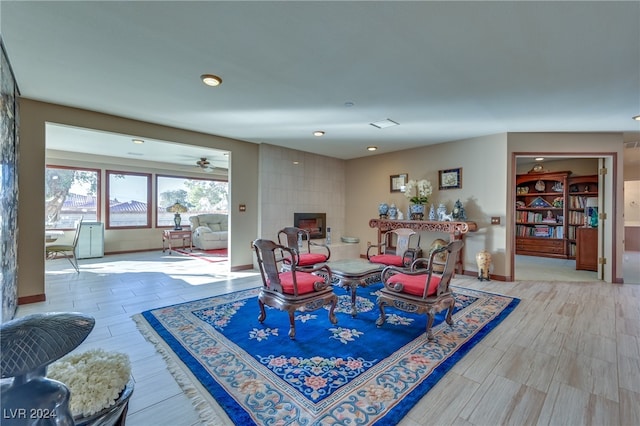 dining area featuring a tile fireplace, hardwood / wood-style floors, and ceiling fan