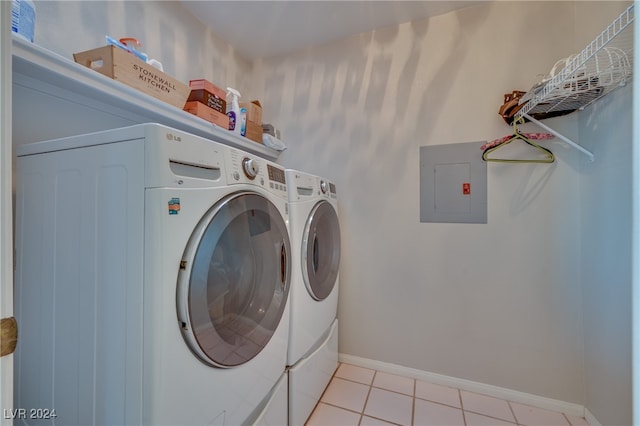 laundry area with light tile patterned floors, electric panel, and washing machine and clothes dryer