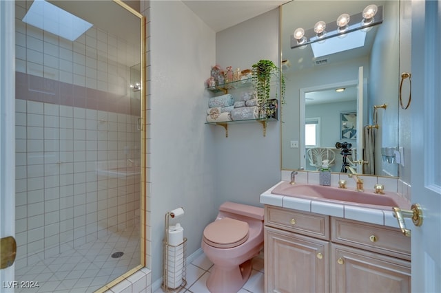 bathroom featuring a skylight, tile patterned floors, an enclosed shower, toilet, and vanity