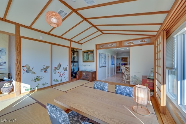 dining room with light hardwood / wood-style flooring and vaulted ceiling