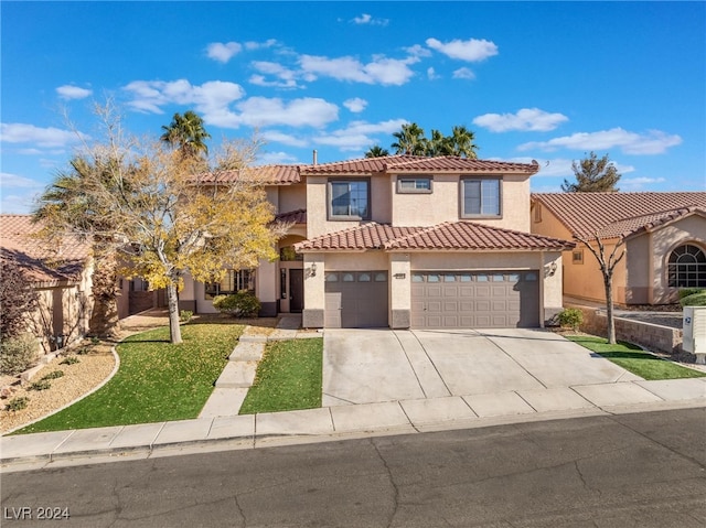 mediterranean / spanish-style home featuring a garage and a front lawn